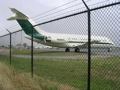 Chain link fences with barbed wires are installed in the airport and a plane in the site.