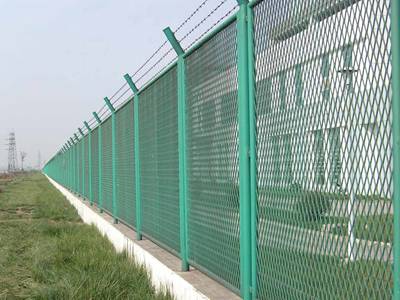 Expanded metal fence with barbed wire is installed as the wall of residence.