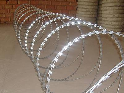 A roll of double spiral concertina razor wire on the ground.