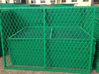 A piece of green color flat type PVC coating straight razor wire fence is lean on the razor wire fence bundle.