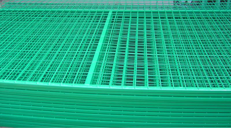 Many green polyester coated welded wire fence panel with tube frame on the ground in our factory.