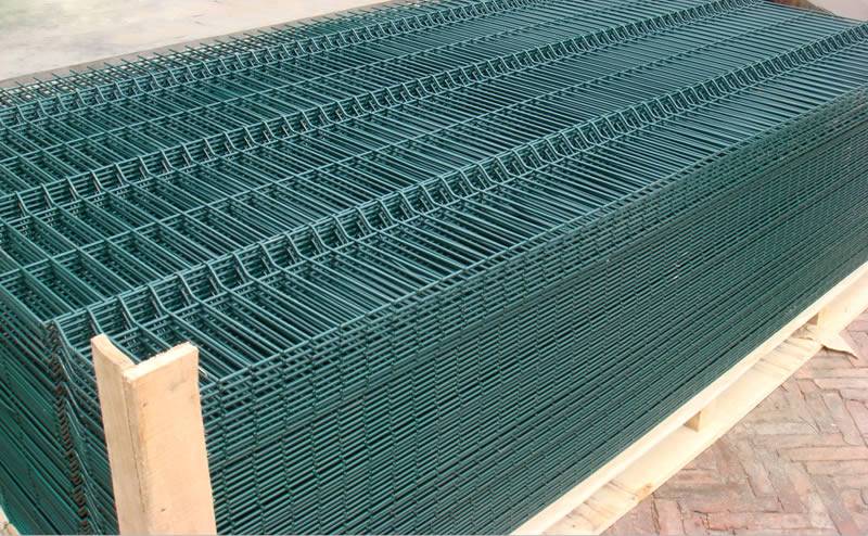 Green polyester coated galvanized welded wire mesh fence panels with wave type packaged on wooden pallet.