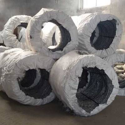 Several rolls of concertina barbed wires with woven bag package in the warehouse.
