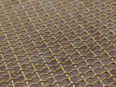A piece of copper alloy crimped wire mesh on the gray background.