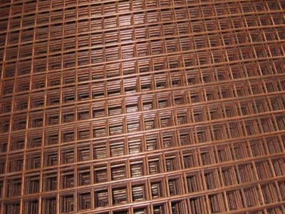 Several pieces of copper alloy welded wire mesh on the gray background.