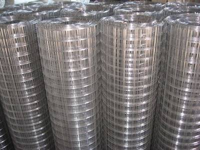 Several rolls of hot dipped galvanized welded mesh on the ground.