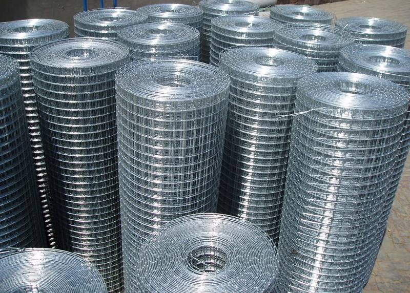 Several rolls of hot dipped galvanized welded wire mesh with bright surface on the ground.