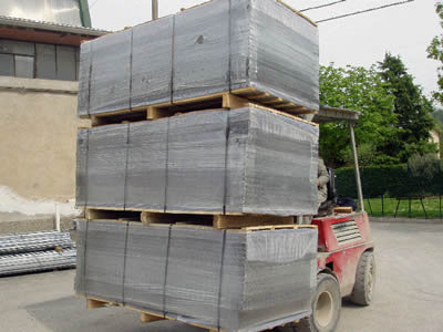 A forklift is carrying three wooden pallets of welded wire mesh with plastic film package.