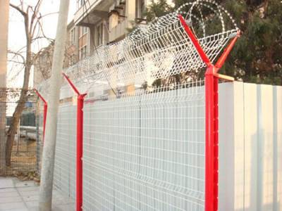 White welded wire mesh panel is installed onto the red peach post with razor wires on the double crank arms.