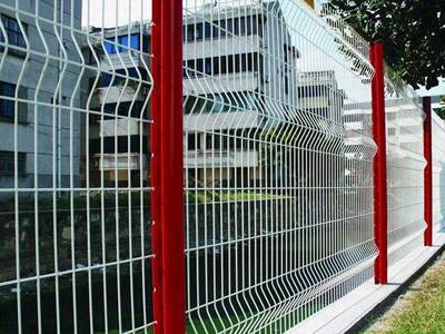 White welded wire mesh panels and red peach posts are installed beside of the residences.