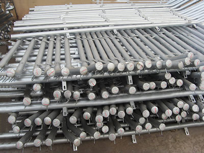 Several galvanized bending type round post on the ground.