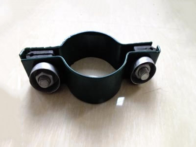 A dark green color metal clamp on the ground.