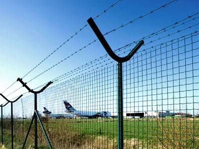 Several euro fences are installed around airport with barbed wire on the top of fence.