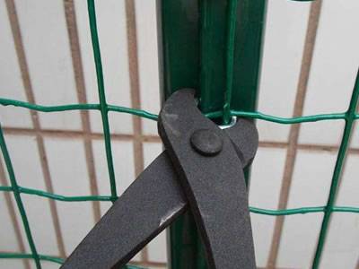 A pliers is fastening the clips onto the Euro fence.