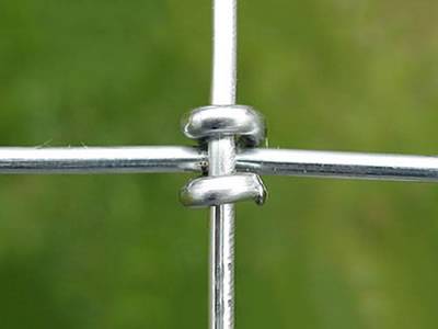 A detail of square joint of woven wire cattle fence.