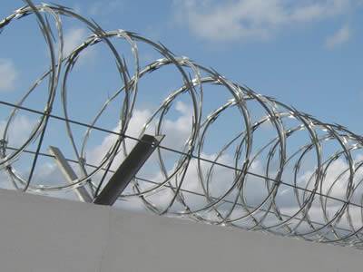 Concertina cross type razor wires are installed on the wall.