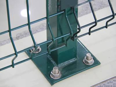 A green color square posts are bolted onto the ground.