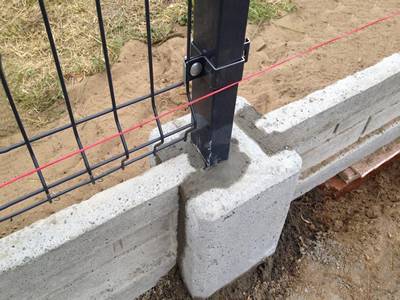 A square post is concreted in the concrete ground.