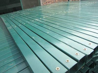 Several pieces of green color PVC coated square post on the ground.