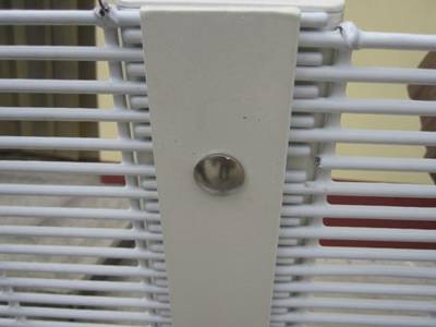 Two pieces of white anti-climb fences are connected by the sheet.