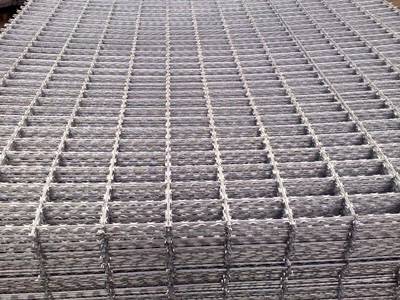 Several pieces of straight razor wire fence panels on the ground.