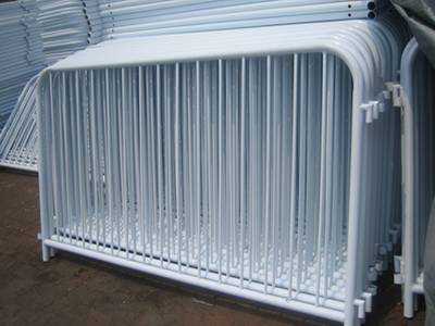 Several galvanized crowd control barriers in the warehouse.