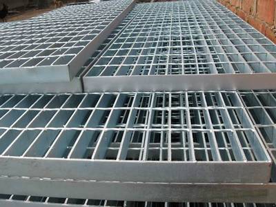 Several press locked galvanized welded steel grating on the ground.